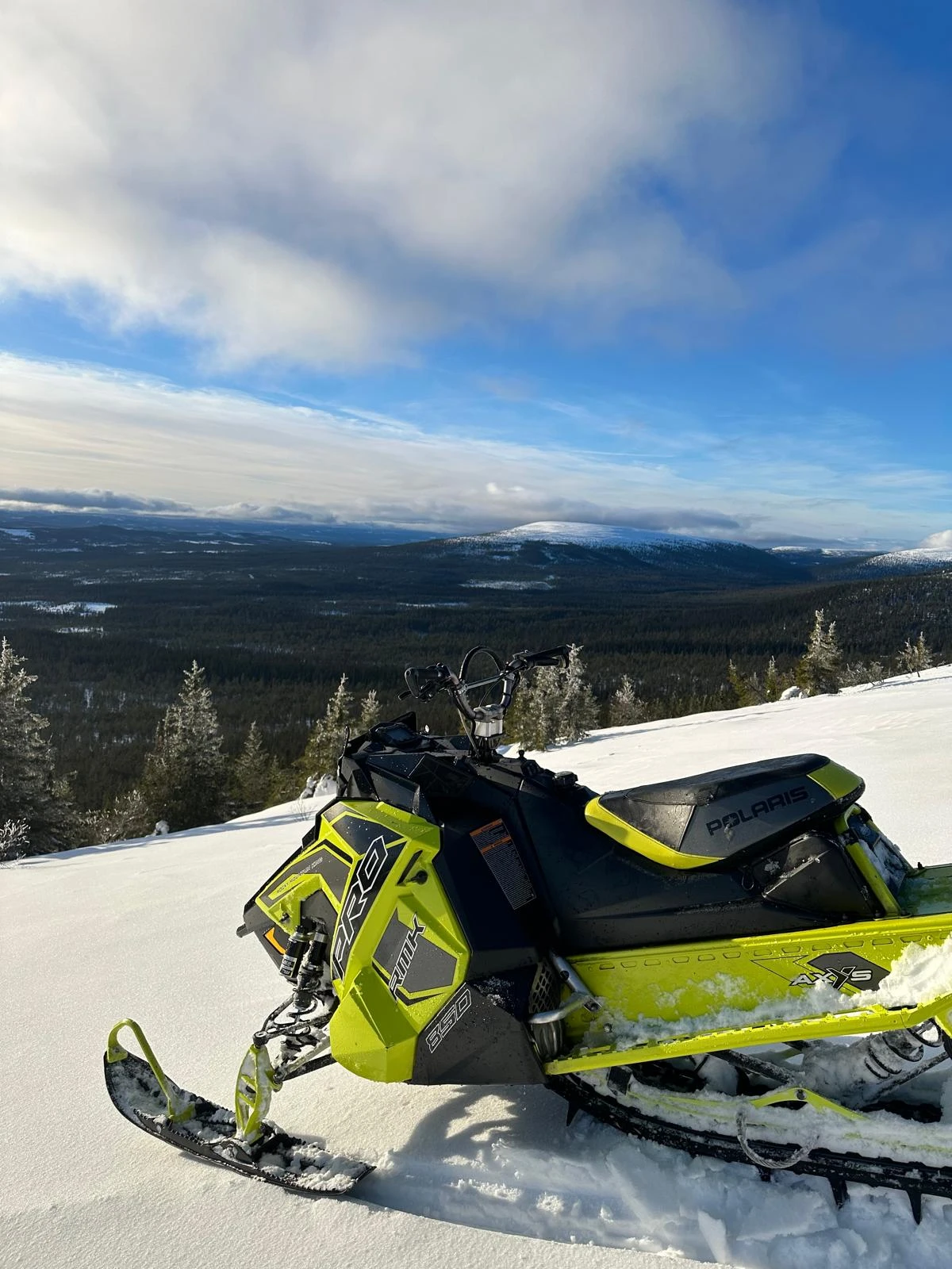 Skuter Śnieżny na tle lasów i gór